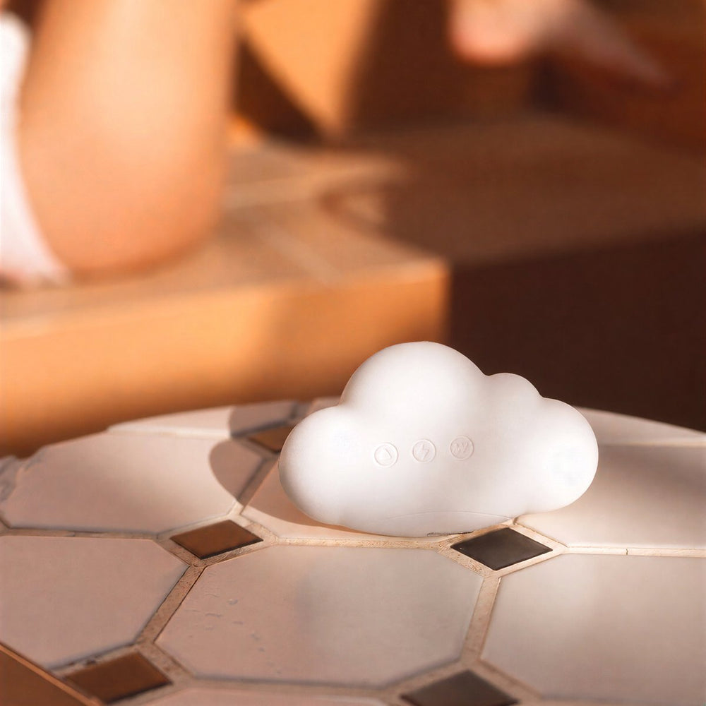 Mousse cloud-shaped toy resting beside bare legs