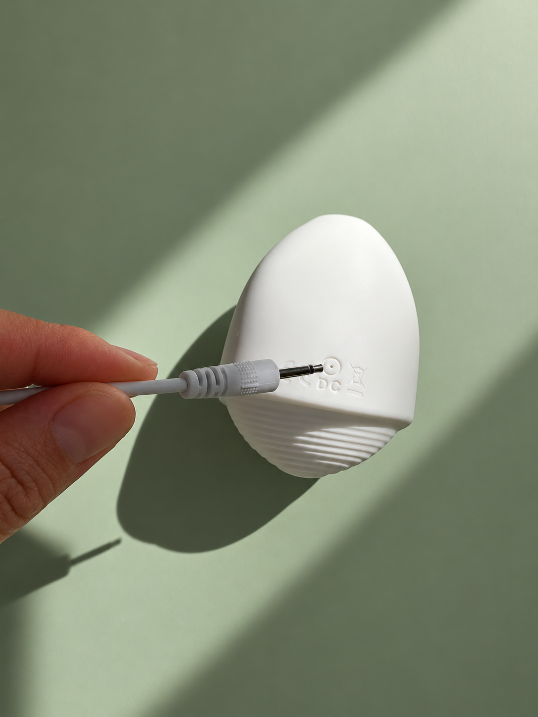 Pépite charging port with charging cable on a sage green background